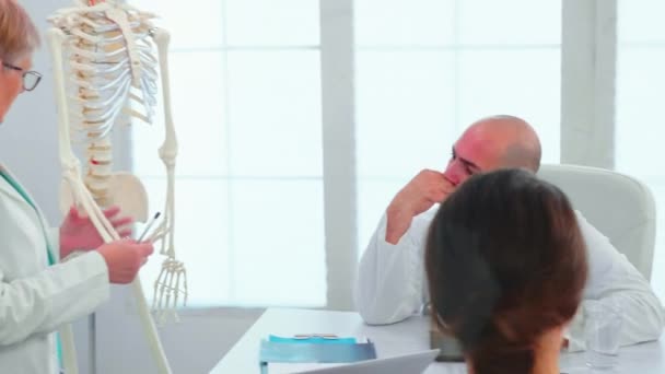 Лікар-жінка викладає анатомію за допомогою людського скелета — стокове відео