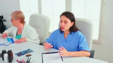 Hasta teşhisini açıklayan deneyimli olgun doktorlar.