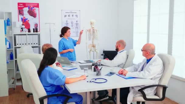 Assistante pointant sur le squelette devant des trucs médicaux — Video