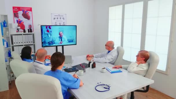 Zespół pracowników medycznych dyskutujących podczas wideokonferencji — Wideo stockowe