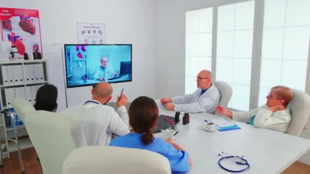 Medicinsk personal som har videokonferens av sjukhusteam med expert läkare — Stockvideo