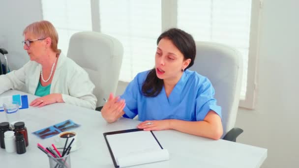 Médico praticante conversando com colega durante briefing de medicina — Vídeo de Stock