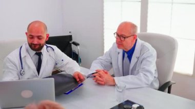Bir grup doktor hastanın omurga radyografisi hakkında tartışıyorlar.