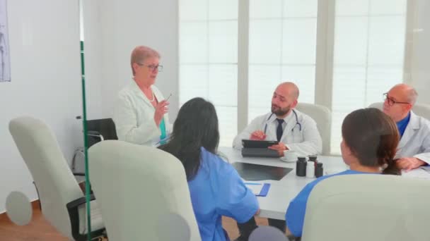 Эксперт пожилая женщина врач обсуждения с медицинским персоналом — стоковое видео