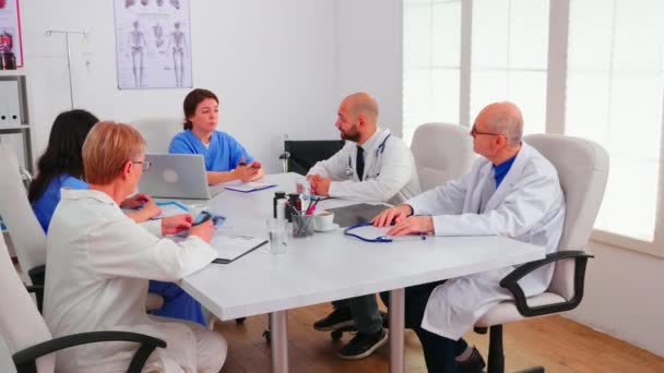 Команда врачей-экспертов проводит брифинг в конференц-зале больницы — стоковое видео