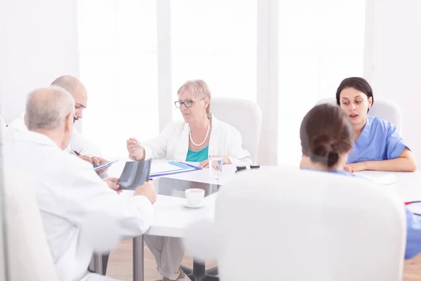 Équipe de médecins experts assis au bureau — Photo