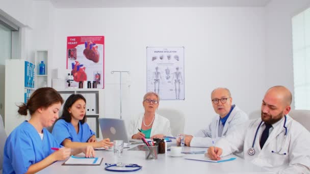 Equipe de médicos discutindo on-line com o chefe de física — Vídeo de Stock
