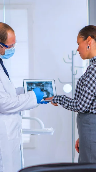 Стоматолог в приемной говорит с пациенткой о рентгене — стоковое фото