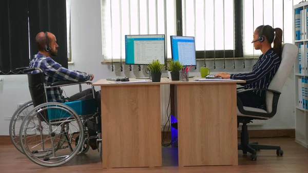 Man in wheelchair using headset making telemarketing — Stock Photo, Image