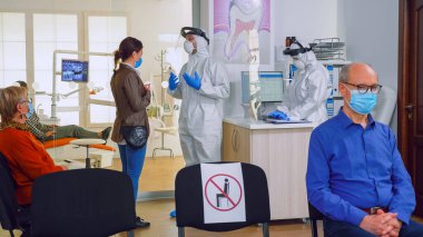 Genel olarak hastayla diş tedavisi hakkında konuşan bir doktor.