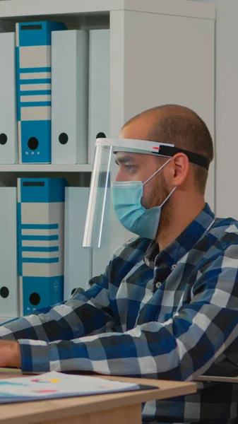 Paralysed businessman with mask typing on computer — Stock Photo, Image