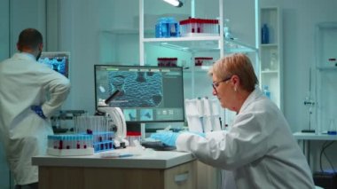 Bilim adamlarından oluşan bir ekip gece geç saatlerde bilgisayarda tartışıyor ve yazı yazıyor.