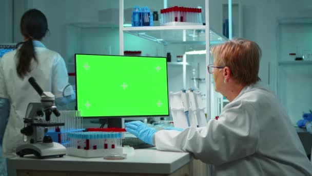 Oudere onderzoeker op zoek naar chroma key display — Stockvideo