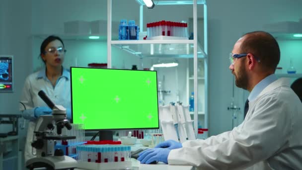 Доктор працює на комп'ютері з зеленим екраном з плином часу — стокове відео