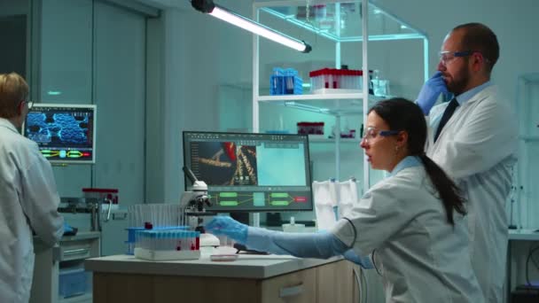 Científicos de investigación que trabajan en PC analizando muestras de material genético — Vídeos de Stock