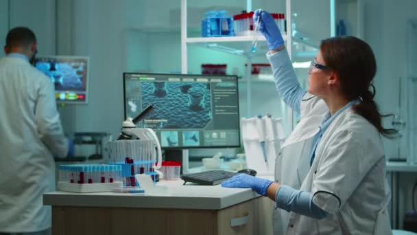 Wetenschapper verpleegkundige typen op pc laat in de avond werken in het laboratorium — Stockvideo