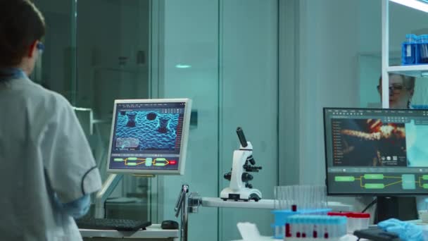Χημικός νοσοκόμος δακτυλογραφεί σε υπολογιστή στέκεται στο εργαστήριο — Αρχείο Βίντεο