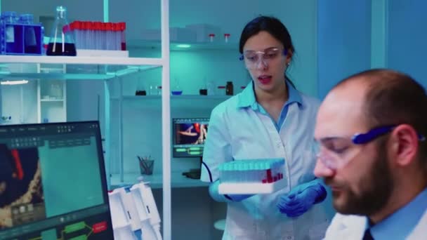 Enfermera química sosteniendo tubos de ensayo llevándolos al médico — Vídeos de Stock