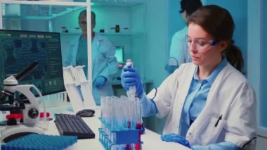 Kimyager mikro pipetle test tüpüne sıvı koyuyor.