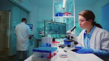 Bilim adamları mikroskop kullanarak virüs gelişimini kontrol ediyor.