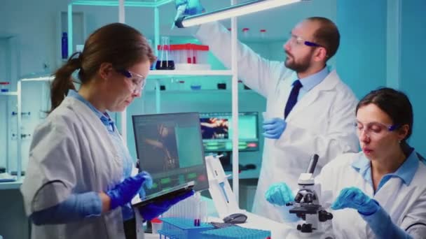 Nurses analysing together virus mutations working overtime — Vídeos de Stock