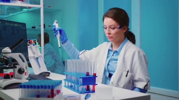 Scientist nurse using micropipette for filling test tubes — Stock Video