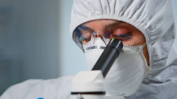 Опытный биолог в костюме, работающий на микроскопах — стоковое фото