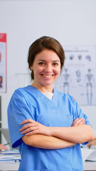 Portrait de jeune infirmière debout devant la caméra souriante — Photo