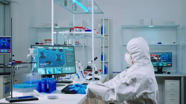 Mecanografía química en PC y compañero de trabajo analizando diapositivas de microscopio — Foto de Stock