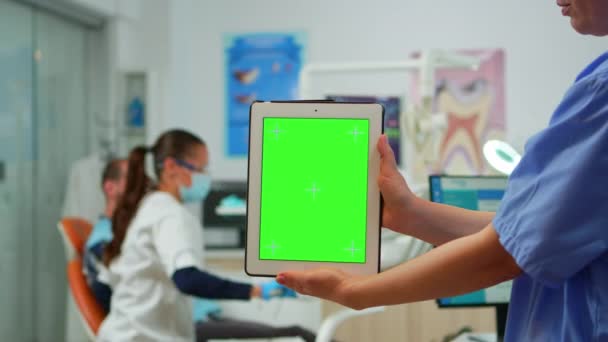 Close up of tablet with green screen display held by dental assistant — Stock Video