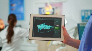 Kapat dişçi asistanı dijital diş izli tablet tutuyor