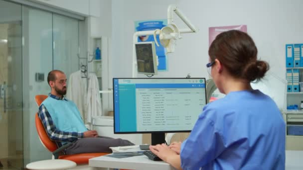 Enfermera escribiendo en la computadora, haciendo citas — Vídeo de stock