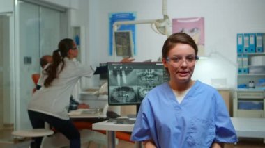 Diş asistanı hastalara ağız hijyeninin önemini anlatıyor.