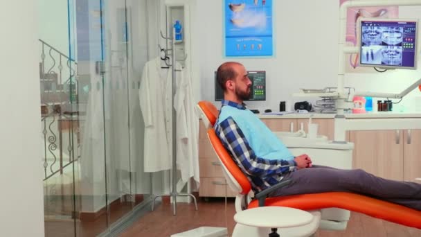 Orthodontist bespreekt MRI scan met patiënt voor de operatie — Stockvideo