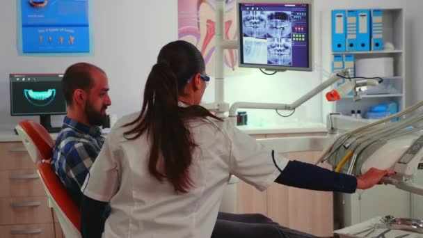 Technicien dentiste avec lunettes expliquant la chirurgie — Video