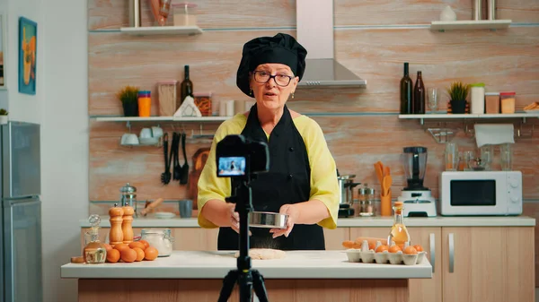 Elderly woman filming cooking vlog