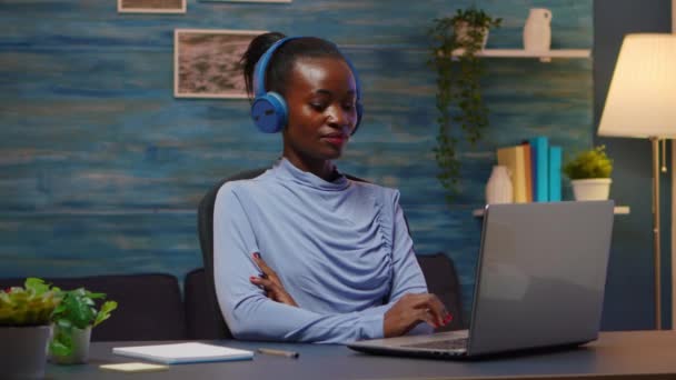 ワイヤレスヘッドフォンをオンラインで聴くアフリカ系アメリカ人 — ストック動画