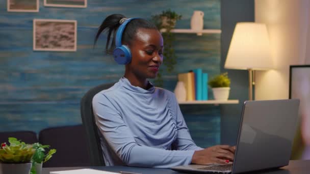 Mujer sonriente de diseño negro con auriculares escuchando música — Vídeos de Stock