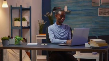 Afrikalı gülümseyen serbest yazar, bilgisayarda yazı yazıyor ve liste yapacak.