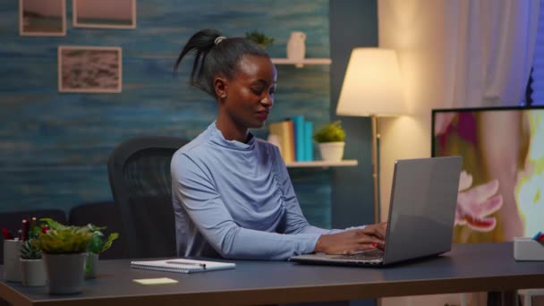 Donna nera che digita sul computer sorridendo a tarda notte — Video Stock