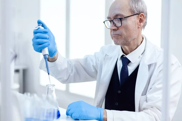 Científico anciano haciendo experimento farmacéutico —  Fotos de Stock