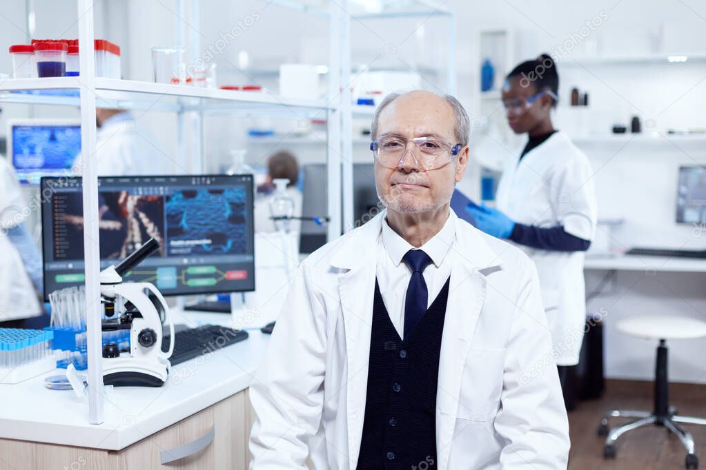 Senior male chemist looking at camera