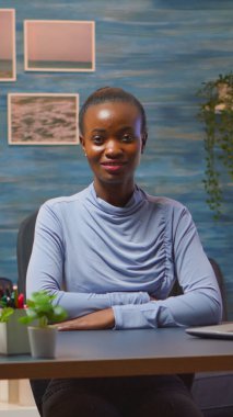 Siyah kadın kameraya bakıp gülümsüyor.