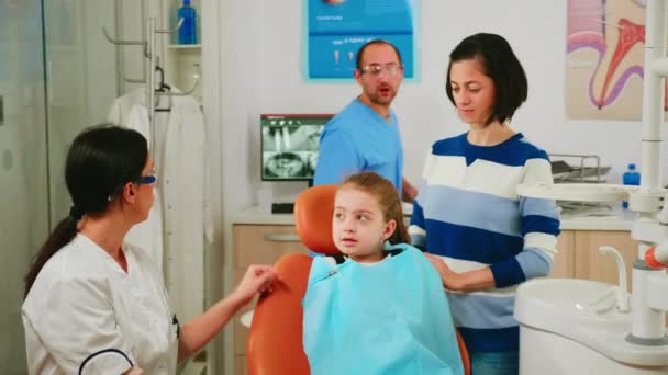 Médico mostrando à criança a higiene dentária correta usando mock-up de esqueleto de dentes — Vídeo de Stock
