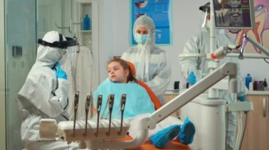 Korumadan sorumlu ortodontist hasta annesi ile konuşuyor.