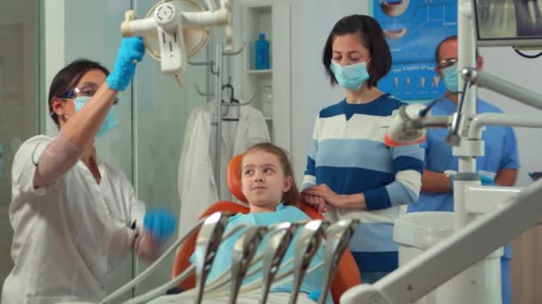 L'ortodontista accende la lampada fino all'esame del bambino — Video Stock
