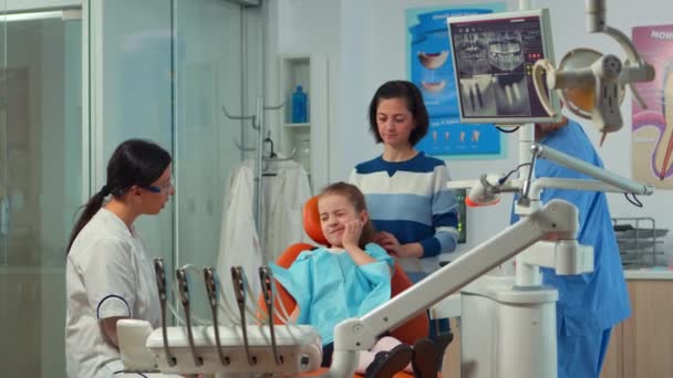 Pediatria kobieta dentysta rozmawia z matką i dziewczyną o higienie jamy ustnej — Wideo stockowe
