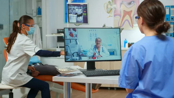 Assister à un appel vidéo avec un médecin stomatologue expert — Photo