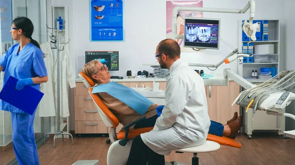 L'ortodontista discute una risonanza magnetica con il paziente — Foto Stock