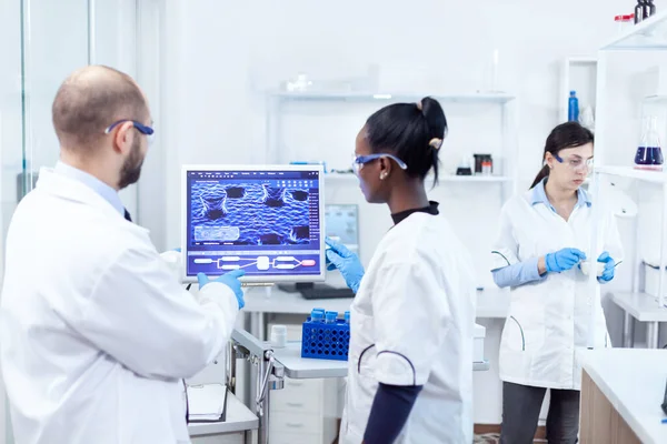 Científico africano y compañero de trabajo discutiendo su investigación — Foto de Stock